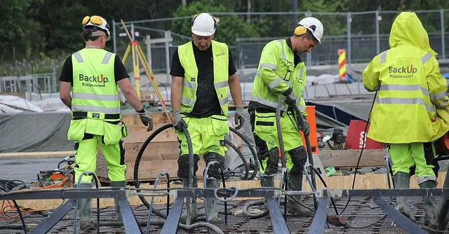 Arbeidere i verneutstyr med backup logo